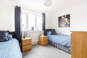 a bedroom with two beds and a window at Modern 3 bedroom home *EVcharging* Garden, Parking in Darlington