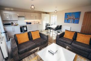 a living room with two couches and a kitchen at The Stay Company, Devonshire Court in Nottingham