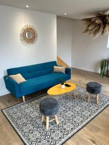 ein Wohnzimmer mit einem blauen Sofa und einem Tisch in der Unterkunft La Maison Majolane, calme & Cosy - 100m du Tram in Meyzieu