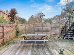 a picnic table on a wooden deck with a fence at Simply Hove By My Getaways in Brighton & Hove