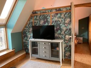 a living room with a television on a dresser at Pyramide Haus 51,8 in Bad Nenndorf