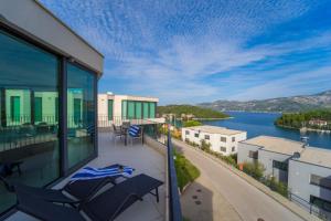 a balcony with chairs and a view of the water at White Cloud Apartments in Korčula