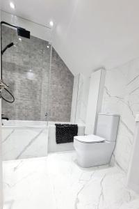 a white bathroom with a toilet and a shower at Modern House in Bournemouth town centre in Bournemouth