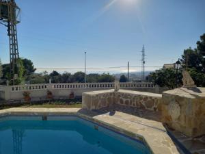 a swimming pool in a yard with a stone wall at Apartamento Montemar I REA-MON2 in Castellón de la Plana