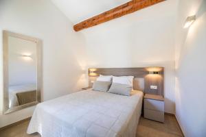 a bedroom with a white bed and a mirror at Résidence Santa Monica in Bonifacio