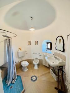 ein Badezimmer mit einem Waschbecken, einem WC und einem Waschbecken in der Unterkunft Villa Basso 2 in Monte SantʼAngelo