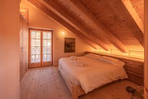 ein Schlafzimmer mit einem großen Bett im Dachgeschoss in der Unterkunft Casa Campo 21 in Cortina d'Ampezzo