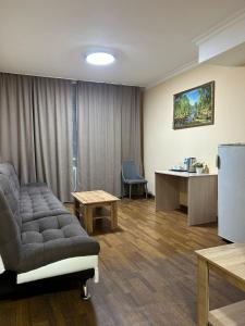 - une salle d'attente avec un canapé, une table et un réfrigérateur dans l'établissement Skif Hotel, à Astana