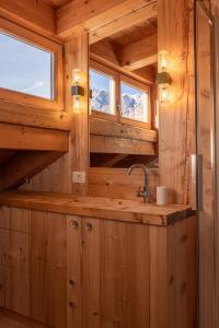 ein Badezimmer mit einem Waschbecken in einer Holzhütte in der Unterkunft Casa Campo 21 in Cortina d'Ampezzo