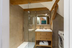a bathroom with a shower and a sink and a washing machine at Chabi Chalet Gîte au coeur d'Eguisheim in Eguisheim