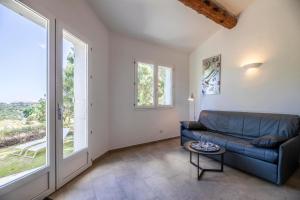 a living room with a couch and large windows at Résidence Santa Monica in Bonifacio