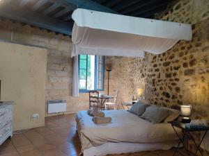 - une chambre avec un grand lit dans un mur en briques dans l'établissement Les suites de charme du Portalet, à Uzès