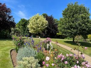 un giardino con molti fiori e alberi diversi di Cotswold Retreat - Private & Peaceful 
