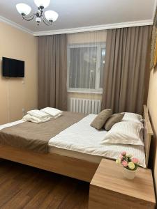 a bedroom with a large bed with a window at Skif Hotel in Astana