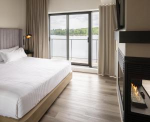 une chambre d'hôtel avec un lit et une cheminée dans l'établissement Estérel Resort, à Estérel