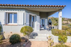 a house with a porch with a table and chairs at Résidence Santa Monica in Bonifacio