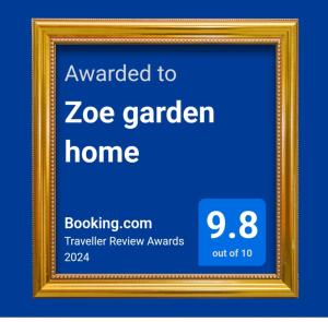 Uma moldura dourada com um cartaz que diz que foi entregue à casa da Zoe Garden. em Zoe garden home em Spata