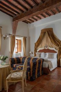 een slaapkamer met een bed en een bank bij Castello di Leonina Adults Only in Casetta