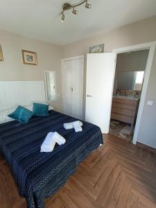 a bedroom with a bed with two towels on it at Precioso ático en el casco antiguo de Triana in Seville