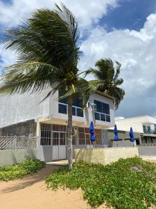 a palm tree in front of a building at BL Maria Bonita Pousada in Maragogi