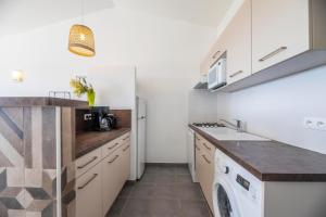 a kitchen with white cabinets and a washer and dryer at Résidence Santa Monica in Bonifacio