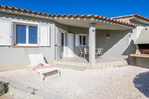 a house with a patio with a table and chairs at Résidence Santa Monica in Bonifacio