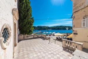 a patio with tables and umbrellas and a body of water at La Porta 2, seaview apartment in the center in Cavtat
