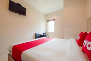 a bedroom with a large bed with red pillows at OYO 1121 Phuree Resort in Sattahip