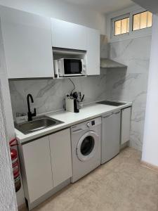a kitchen with a sink and a washing machine at Tamarindo 5 in Benalmádena