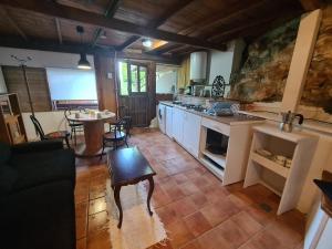 uma grande cozinha com uma mesa e uma sala de jantar em Refugio Finca El Canu em Valdaliga 