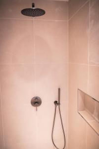 a shower with a shower head in a bathroom at Renovated Parkside Gem - 2 person studio in the Pijp in Amsterdam