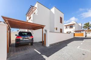 a car parked in a parking lot in front of a house at Villa Nica in Costa Teguise