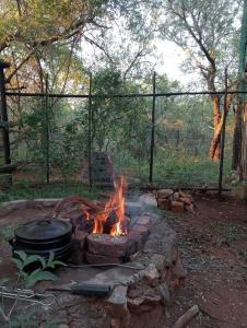 a fire pit with a pot on top of it at Hedgehog Cabin in Marloth Park