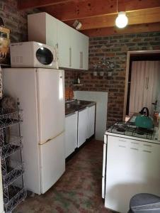 a kitchen with a white refrigerator and a stove at Hedgehog Cabin in Marloth Park +33 photos