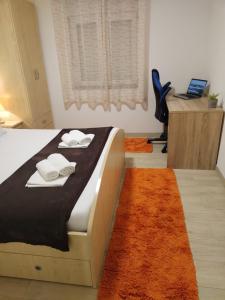 a bedroom with a bed and a desk with a laptop at Apartments Valentino in Gradac