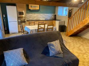 a living room with a couch and a kitchen at Chez Élise et Jean Yves in Job