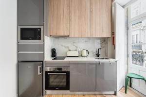 a kitchen with stainless steel appliances and wooden cabinets at A charming stay near Paço das Escolas in Coimbra