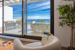 a living room with a chair and a balcony at Luxury penthouse with huge terrace and sea and golf views in San Roque