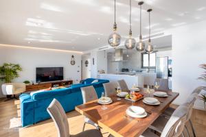 a dining room and living room with a blue couch at Luxury penthouse with huge terrace and sea and golf views in San Roque