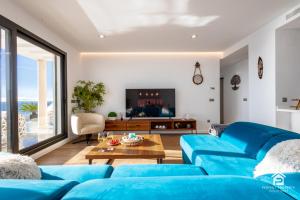 a living room with blue couches and a tv at Luxury penthouse with huge terrace and sea and golf views in San Roque