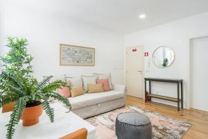 a living room with a couch and a potted plant at A charming stay near Paço das Escolas in Coimbra