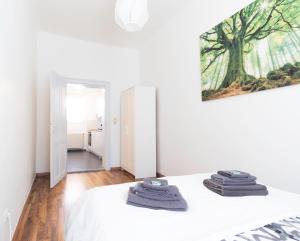 ein Schlafzimmer mit einem weißen Bett und einem Gemälde an der Wand in der Unterkunft Märzstraße Apartment in Wien