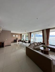 ein großes Wohnzimmer mit einem Sofa und einem Tisch in der Unterkunft Tiara Bunga Hotel & Villa in Balige