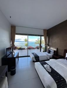 una camera d'albergo con due letti e vista sull'oceano di Tiara Bunga Hotel & Villa a Balige