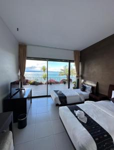 a hotel room with two beds and a view of the ocean at Tiara Bunga Hotel & Villa in Balige