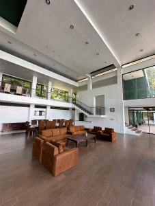 una gran sala de estar con sofás y una mesa. en Tiara Bunga Hotel & Villa, en Balige