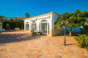 a house with a patio with a table and chairs at Villa Garlanda - PlusHolidays in Benissa