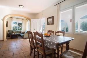 a kitchen with a table and chairs and a living room at Villa Garlanda - PlusHolidays in Benissa