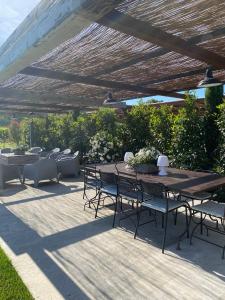 a patio with a table and chairs under a pergola at Mas Serena in Ménerbes