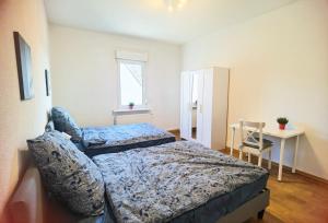 a bedroom with two beds and a table and a chair at Bad Homburg Wohnung in Bad Homburg vor der Höhe